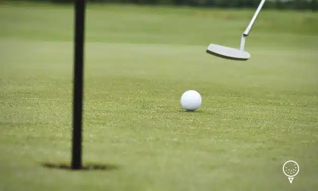 Balle de golf roulant vers le trou sur le green